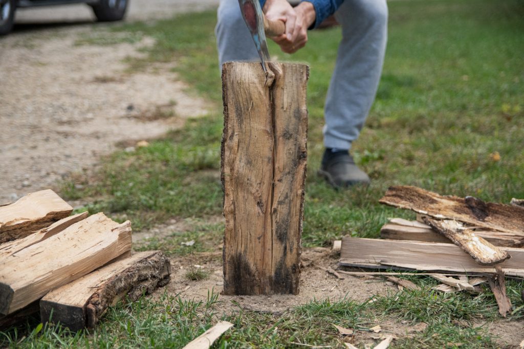 A man splitting firewood with an axe.