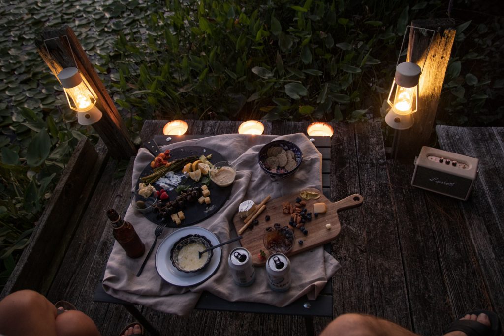 A romantic image of two people looking at a table with finished platters that once had cheese and charcuterie.