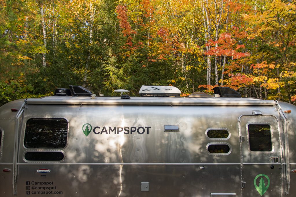 The top of an Airstream trailer with colorful fall foliage at Wildfox Cabins and Campground in Lakeville, ME..