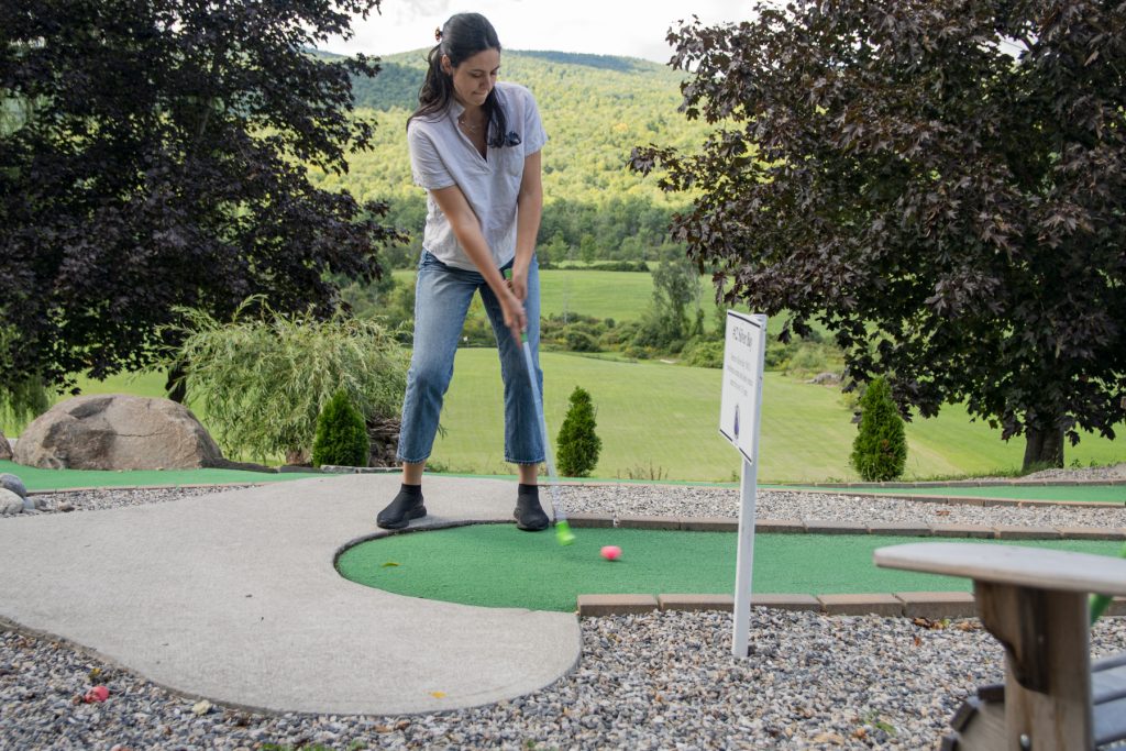 A woman puts a ball at a mini golf course in Ticonderoga, New York.