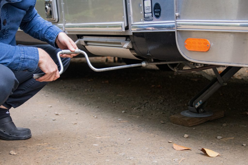 A man puts down the stabilizers of his RV. 