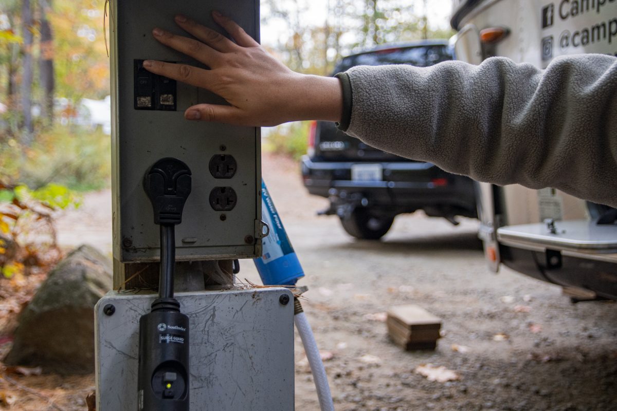 A person connects an RV to shore power for electricity. Shore power is electrical power coming from an external sources so that the RV doesn't have to use its battery.