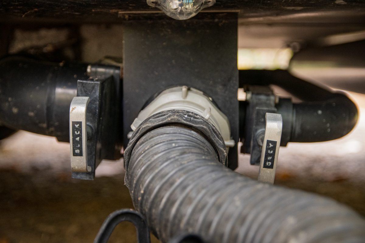 The black water and grey water calves on an RV trailer. A sewage hose is connected to the tank output.