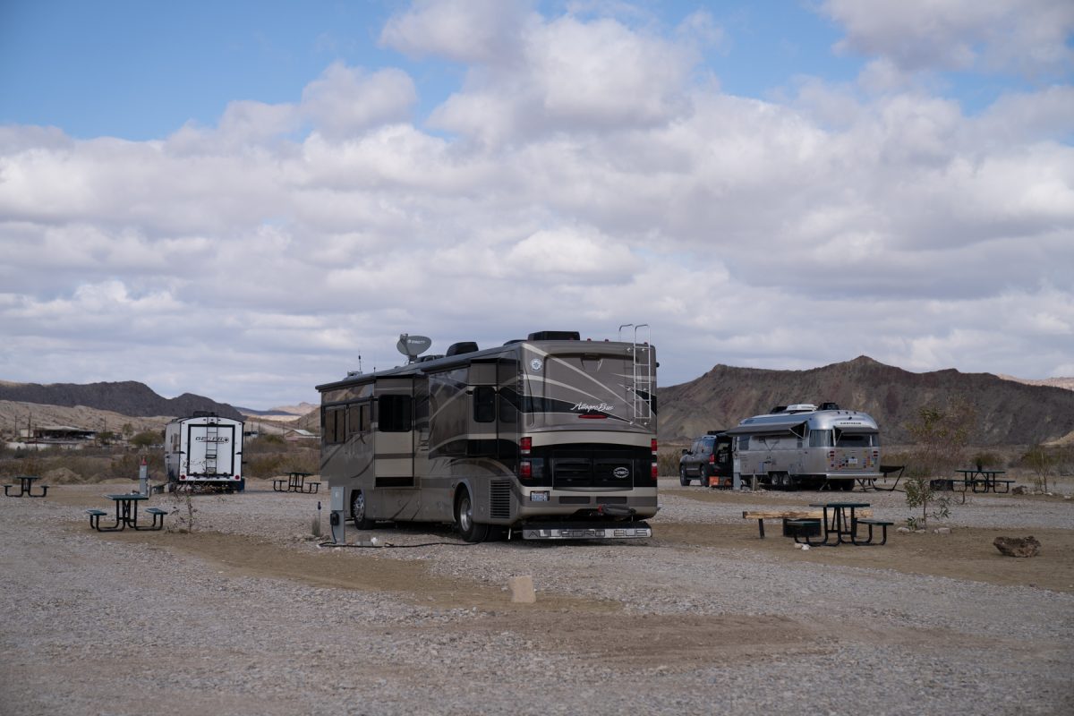 A Class A motorhome coach sits at a campsite at Road Runner Travelers Campground in Terlingua, Texas. A hula skirt is attached to the back of the RV to prevent rocks from flying up behind the motorhome.