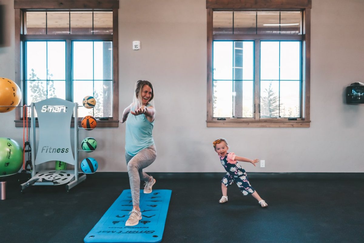 SunFit Wellness Center with mom doing yoga and little girl playing