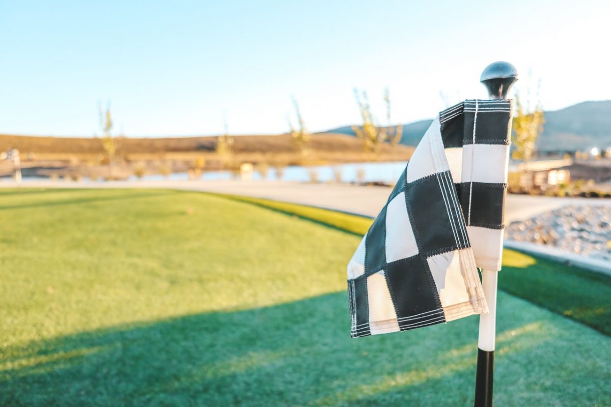 Mini-golf flag with water and mountains in background