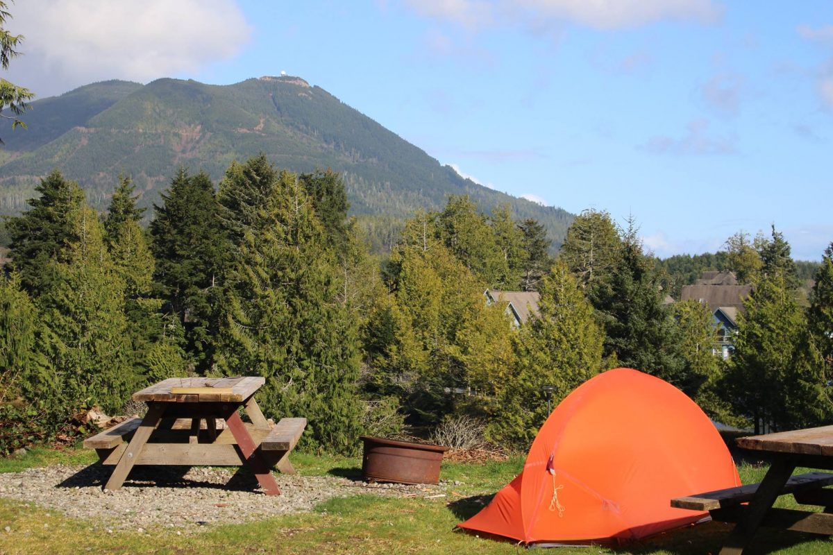 Small orange tent site overlooking mountain view in Ucluelet, BC.