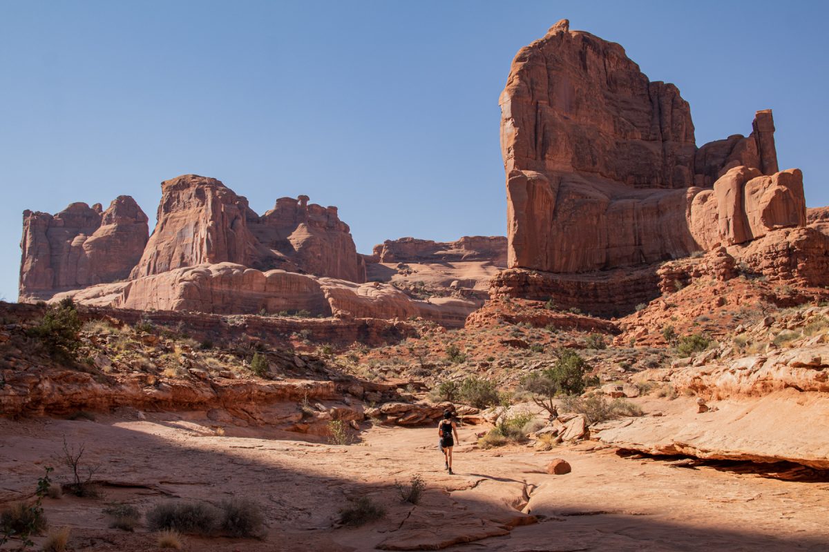 A woman hikes the Park Avenue & Courthouse Tower trail in Arches National Park in Moab, Utah.