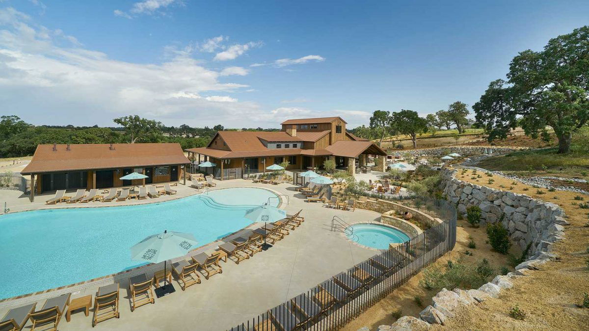 Pool and hot tub area with trees in the background at Cava Robles. 