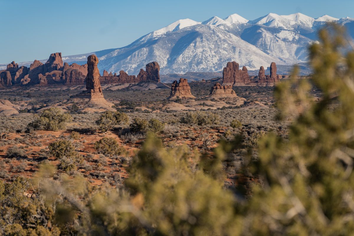 The La Sal Mountain range sits in front of the red rock formations of Arches National Park in Moab, Utah.