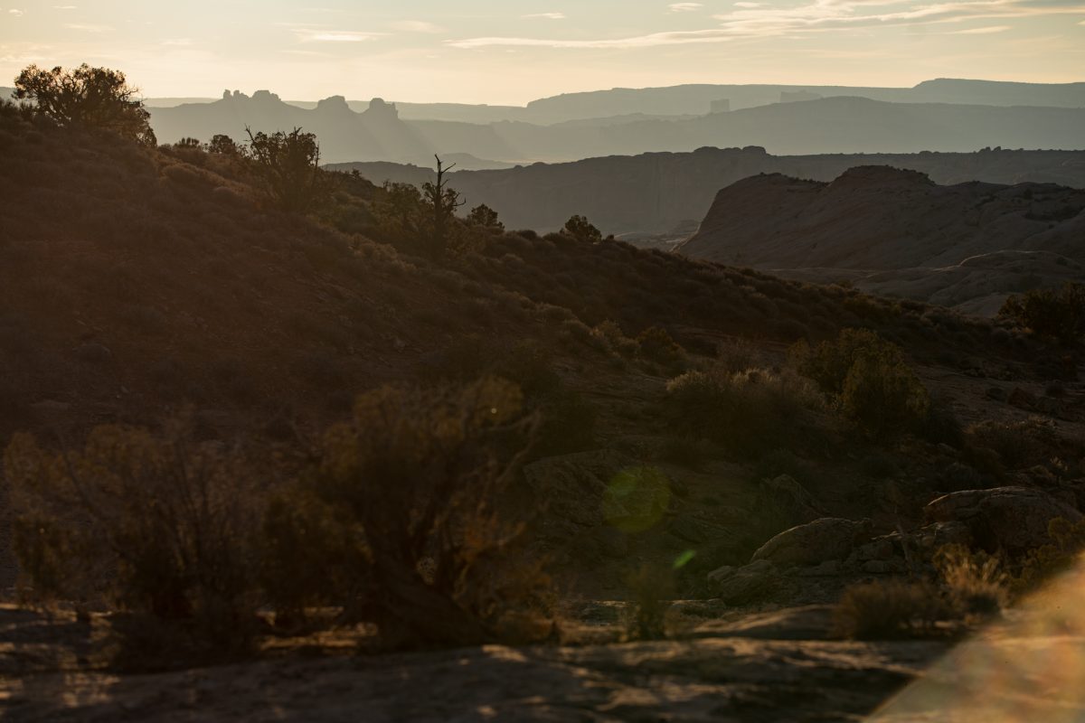 Sunset in Arches National Park in Moab, Utah. Layers of sandstone and rock formations can be seen in the distance.