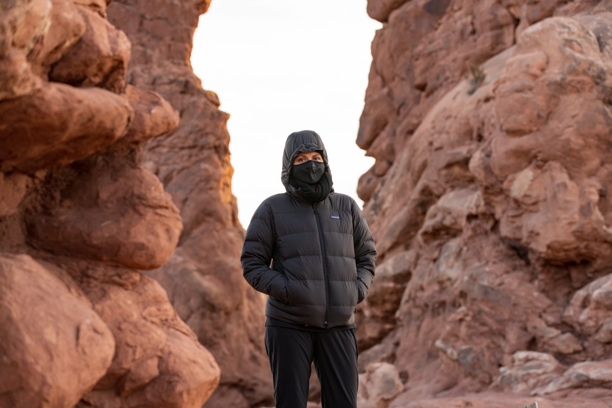 A woman wears a mask while hiking under the Turret Arch in Arches National Park in Moab, Utah.