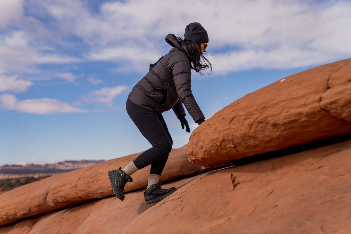 A woman hikes up the slickrock on the Delicate Arch trail in Arches National Park in Moab, Utah.