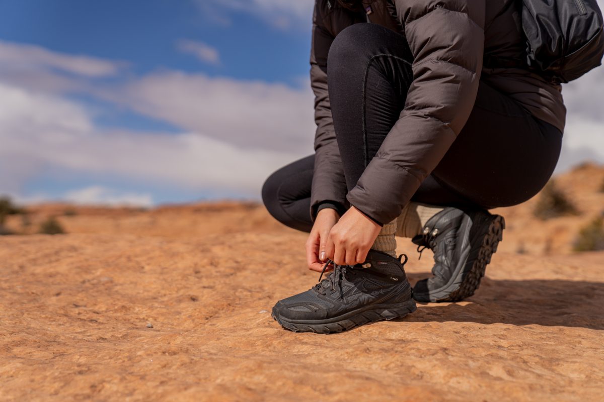 A hiker ties the laces on their hiking boot while on the Delicate Arch trail in Arches National Park in Moab, Utah.