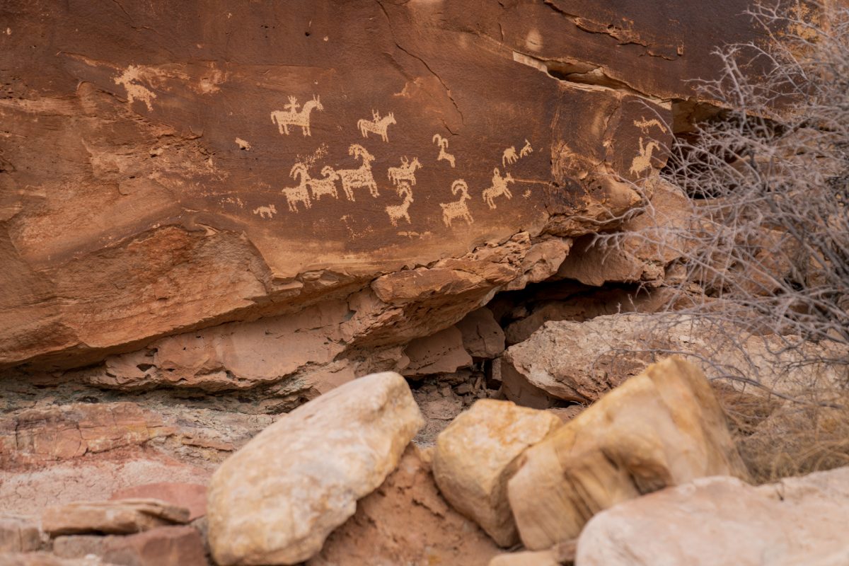 The Ute art petroglyph panel depicting hunters on horses pursuing big horn sheep.