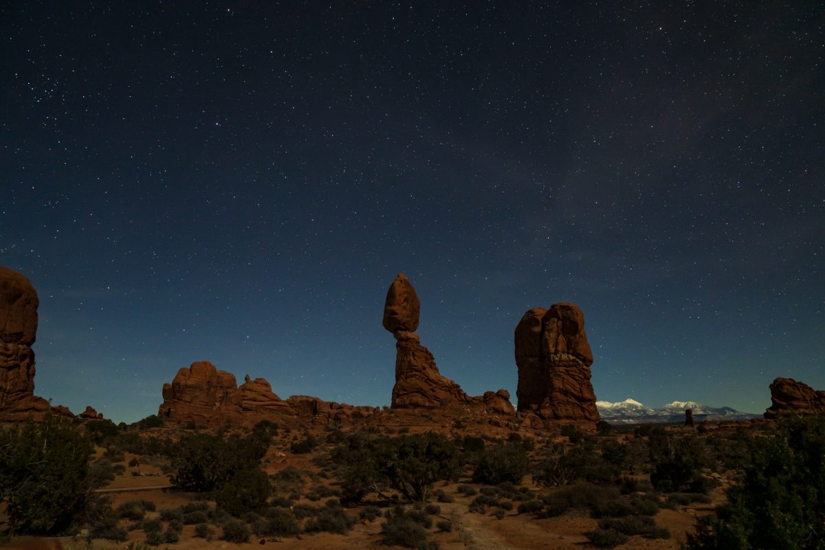 A nighttime image of Balanced Rock in Arches National Park in Moab, Utah. The snow-covered La Sal mountains can be seen in the background.