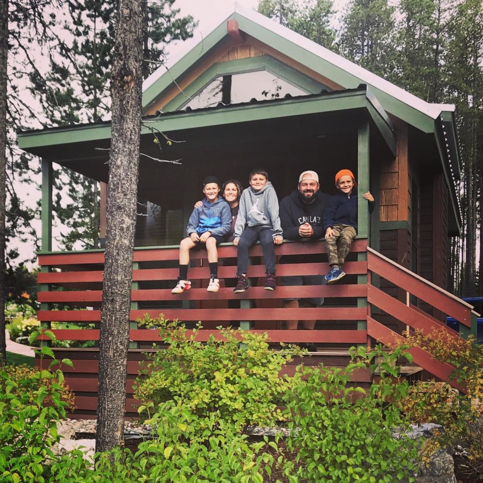 Family sitting outside of a cabin