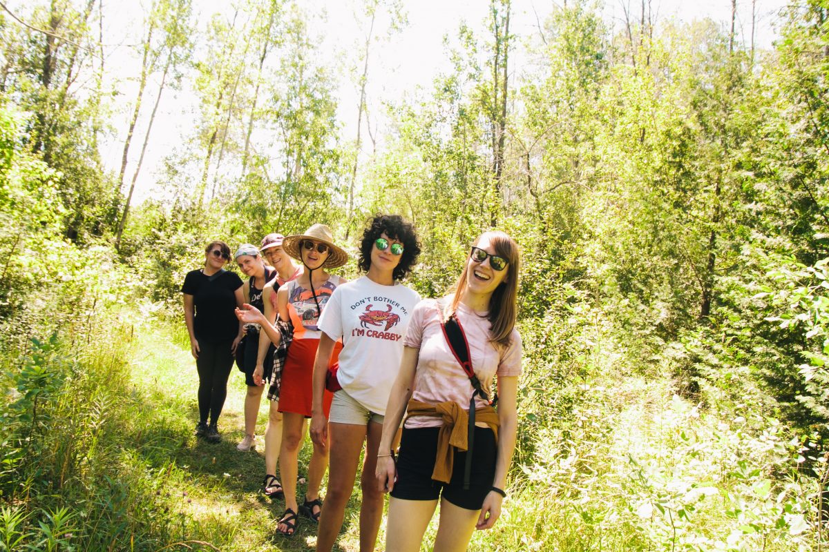 A group of six women hiking in the woods in Northern Michigan.