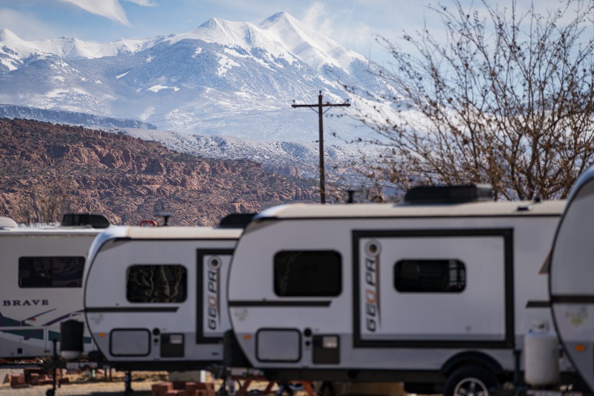 Geo Pro RVs in a line at OK RV Park in Moab, Utah, with snowy La Sal Mountains in the background.