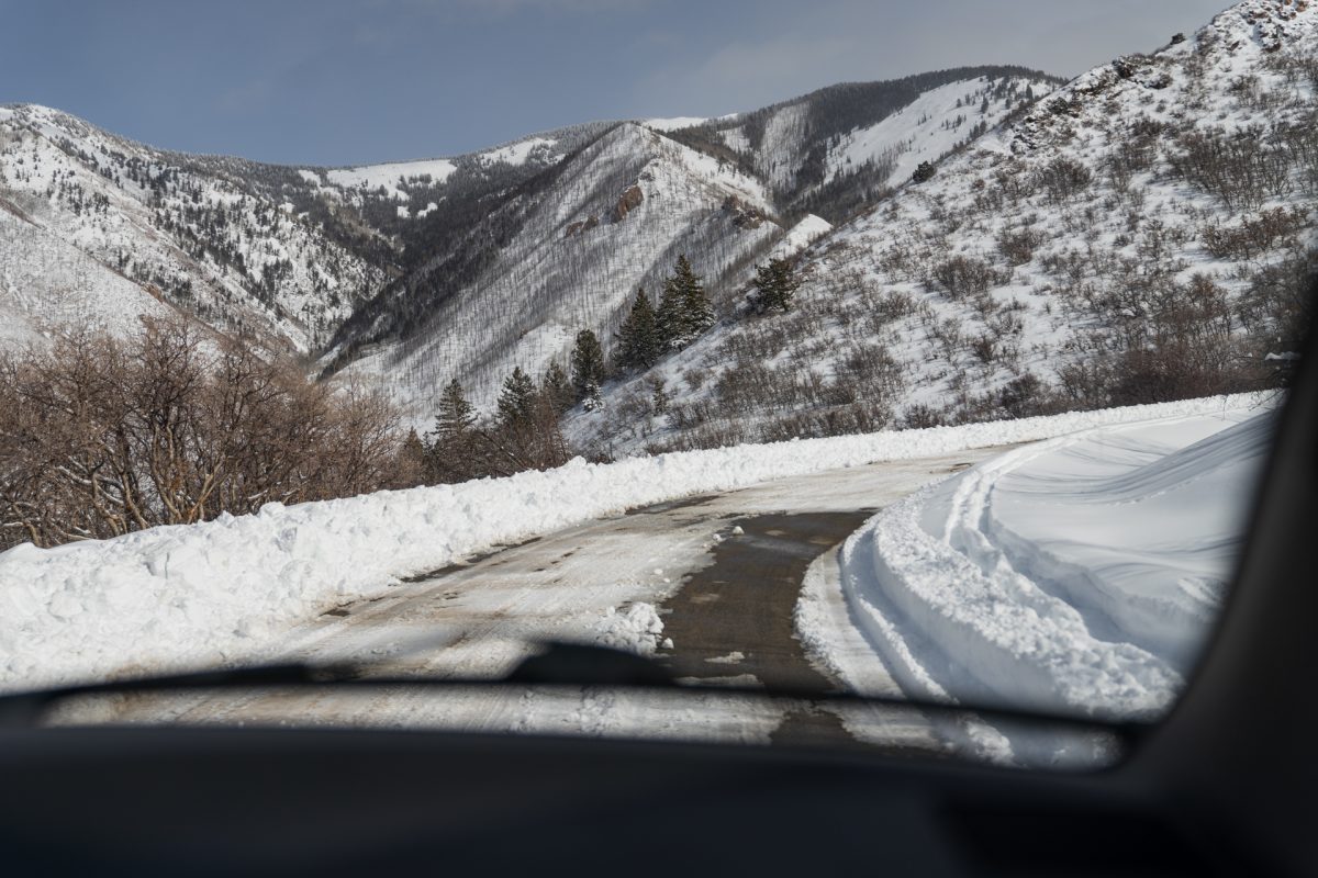 Snow covering the La Sal Mountains as someone drives along the La Sal Mountain Loop road in Moab Utah.