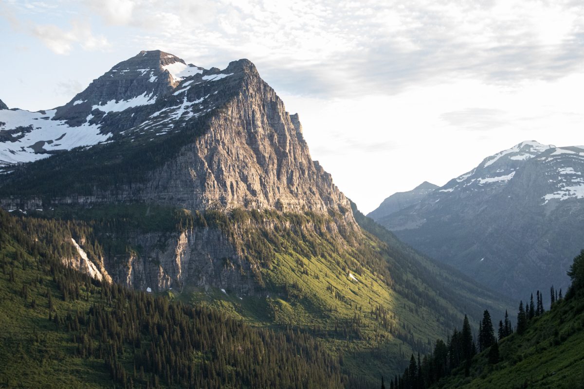 The sun rises on a mountain and valley at Glacier National Park in Montana.