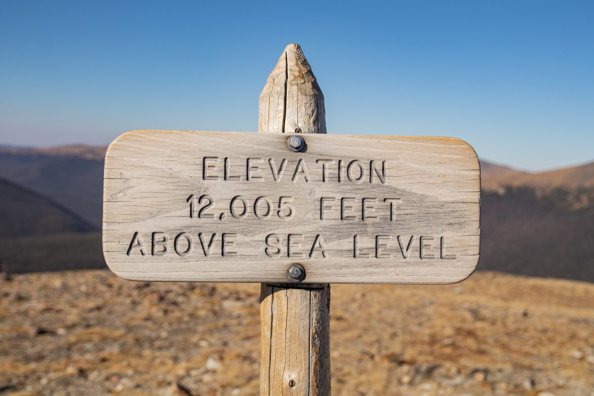 A sign that reads "Elevation 12,005 feet above sea level" at Rocky Mountain National Park in Colorado.