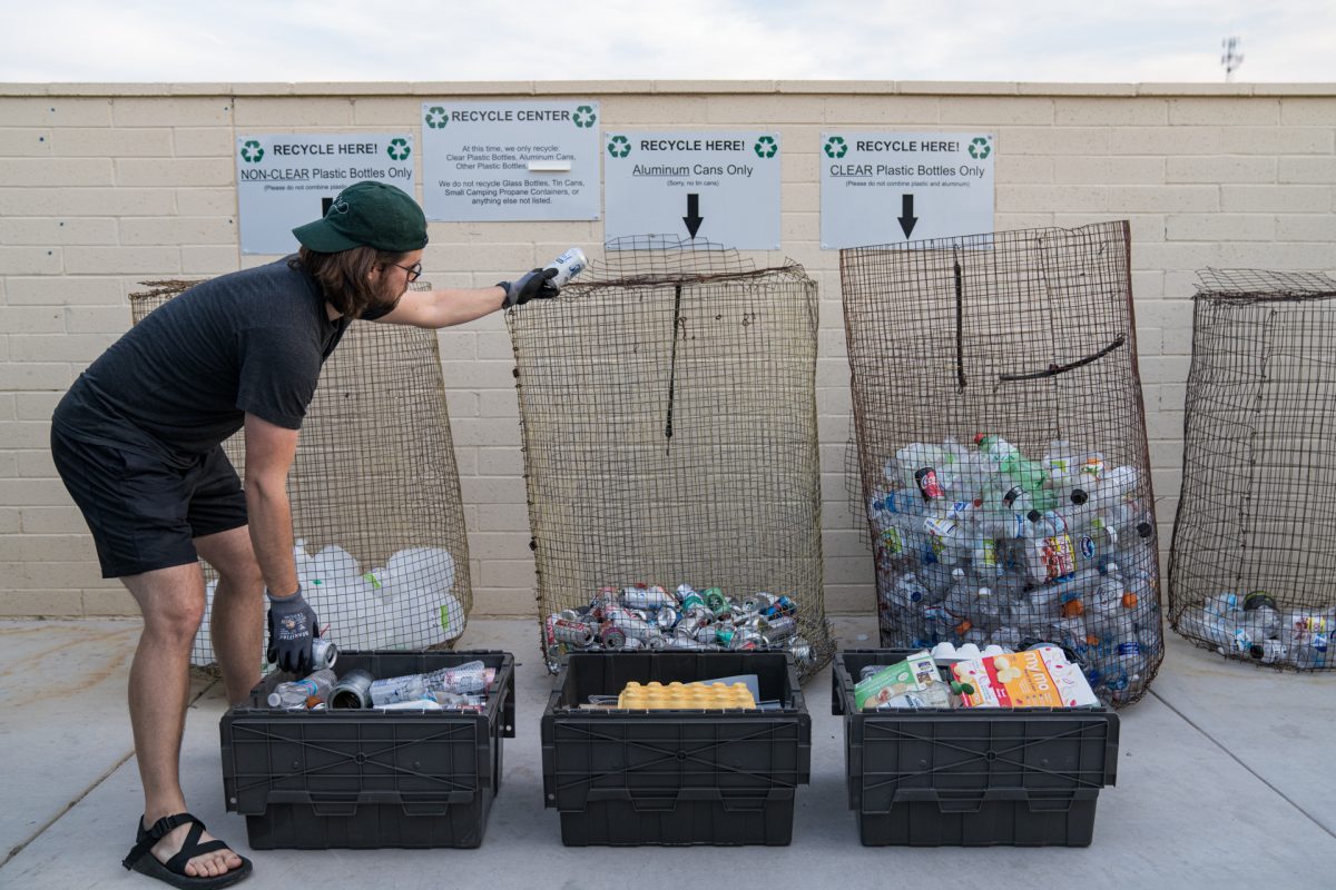 A man separates his recyclables into different recycling bins at a Sonoran RV Resort in Gila Bend, Arizona.