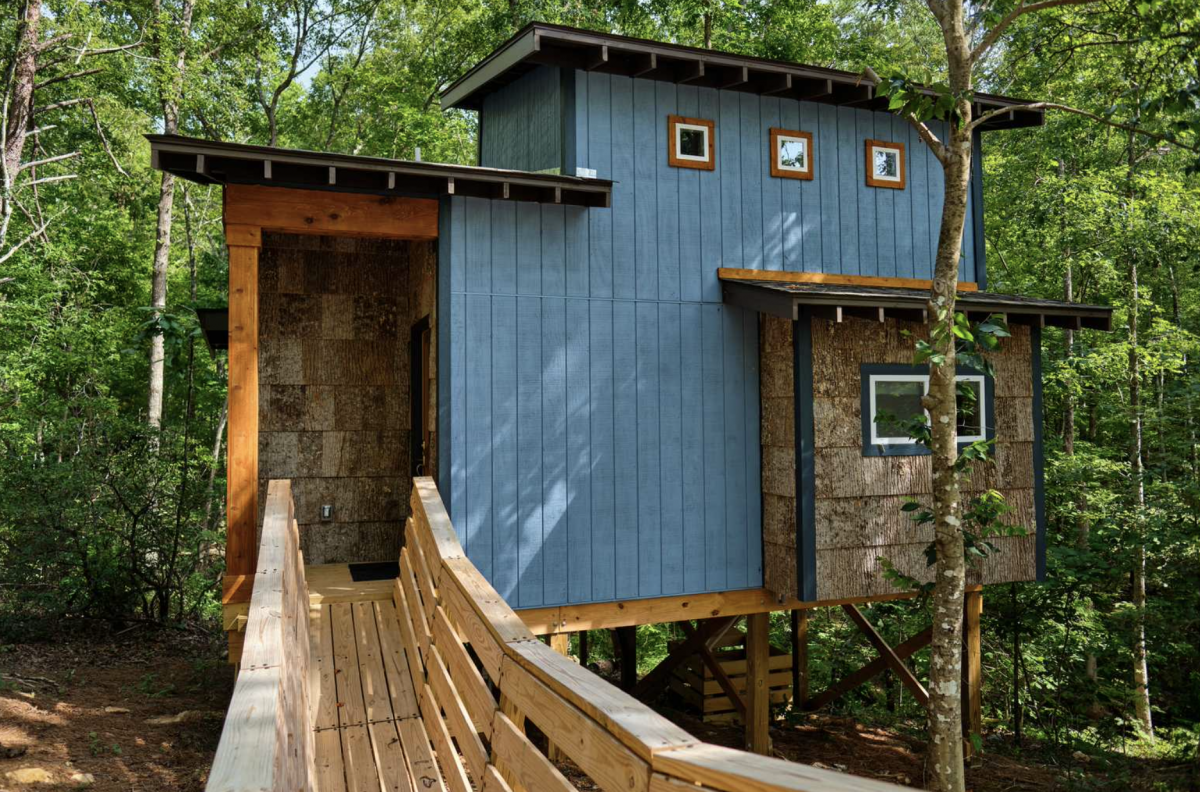 Blue tree house in the woods with walkway