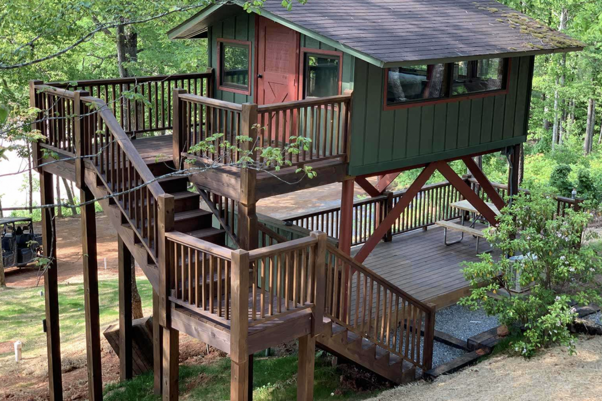 Lake view treehouse cabin in the woods with stairs. 