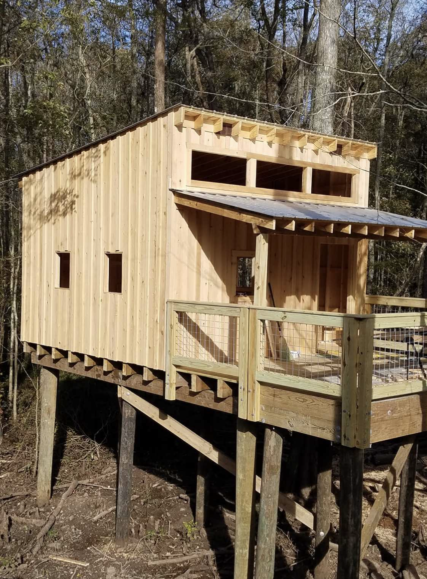 Heightened wooden treehouse in the woods at Cashie River Treehouses and Campground in Windsor, NC