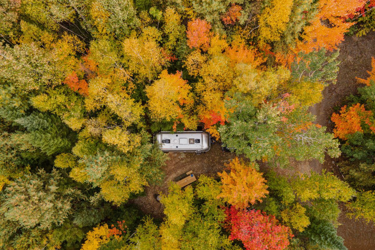 Ariel photo of an Airstream RV in the woods during the fall at Wild Fox Cabins & Campground