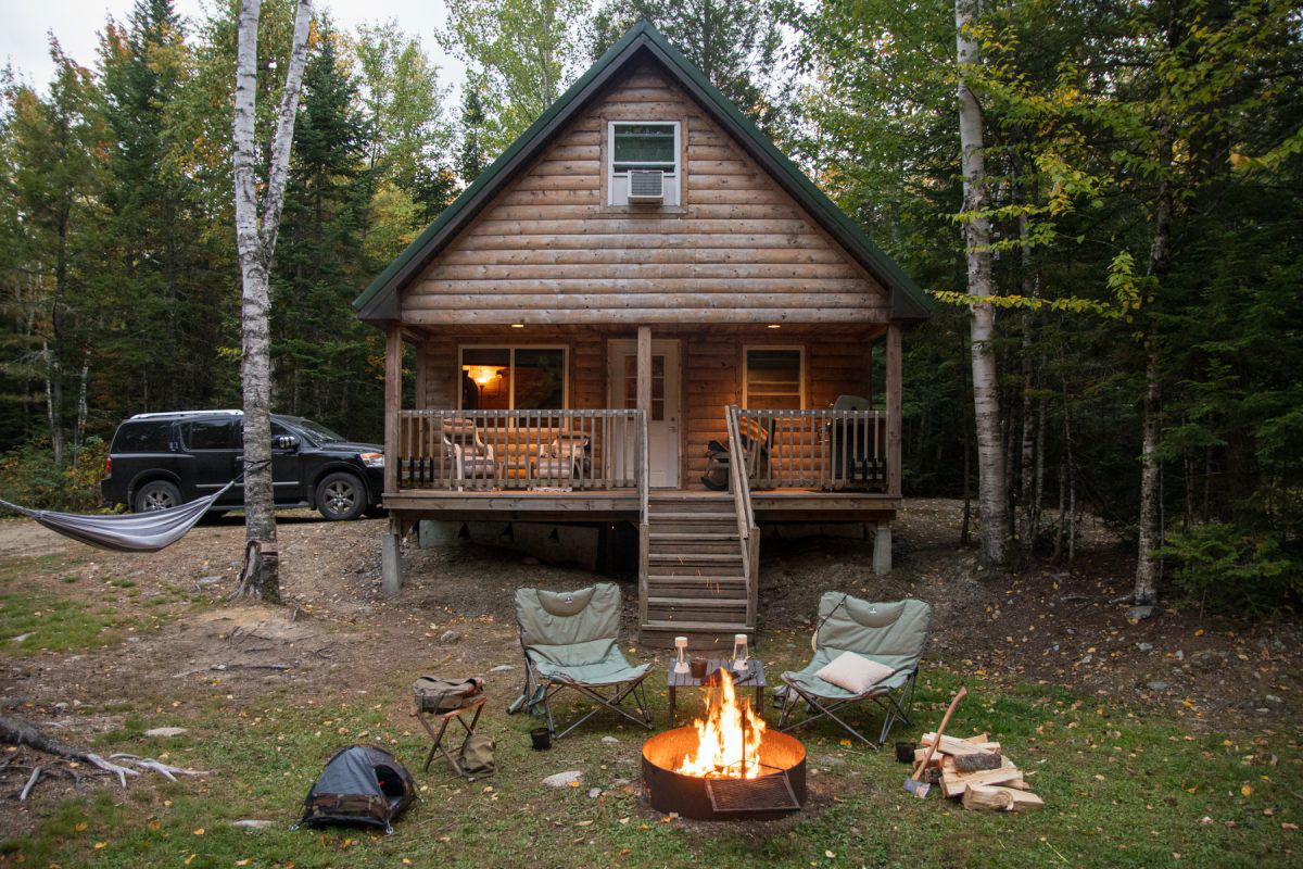 Fire and camping chairs in front of a glampign cabin in the woods at Wild Fox Cabins & Campground