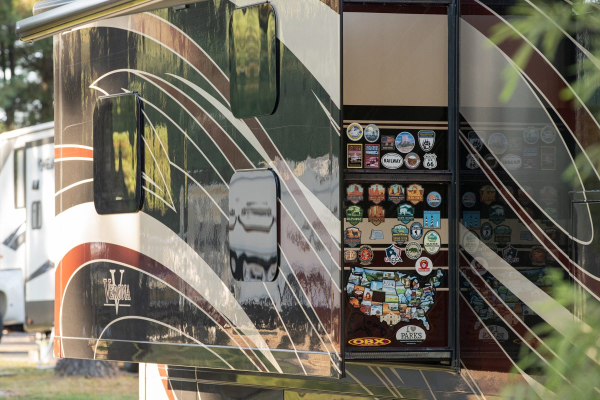 A collection of National Parks stickers are gathered on a slide-out of an RV trailer.