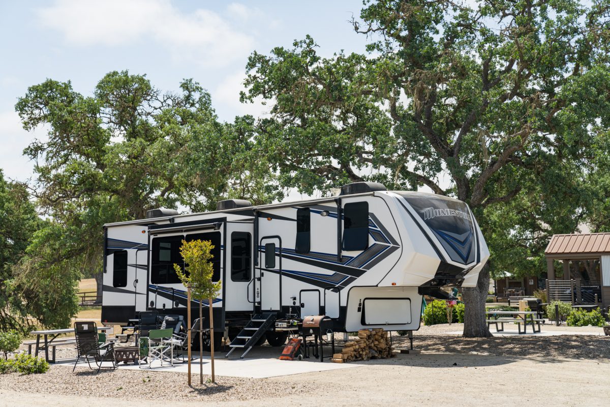 A fifth-wheel trailer sits underneath old oak trees at the Cava Robles RV Resort in Paso Robles, California. 