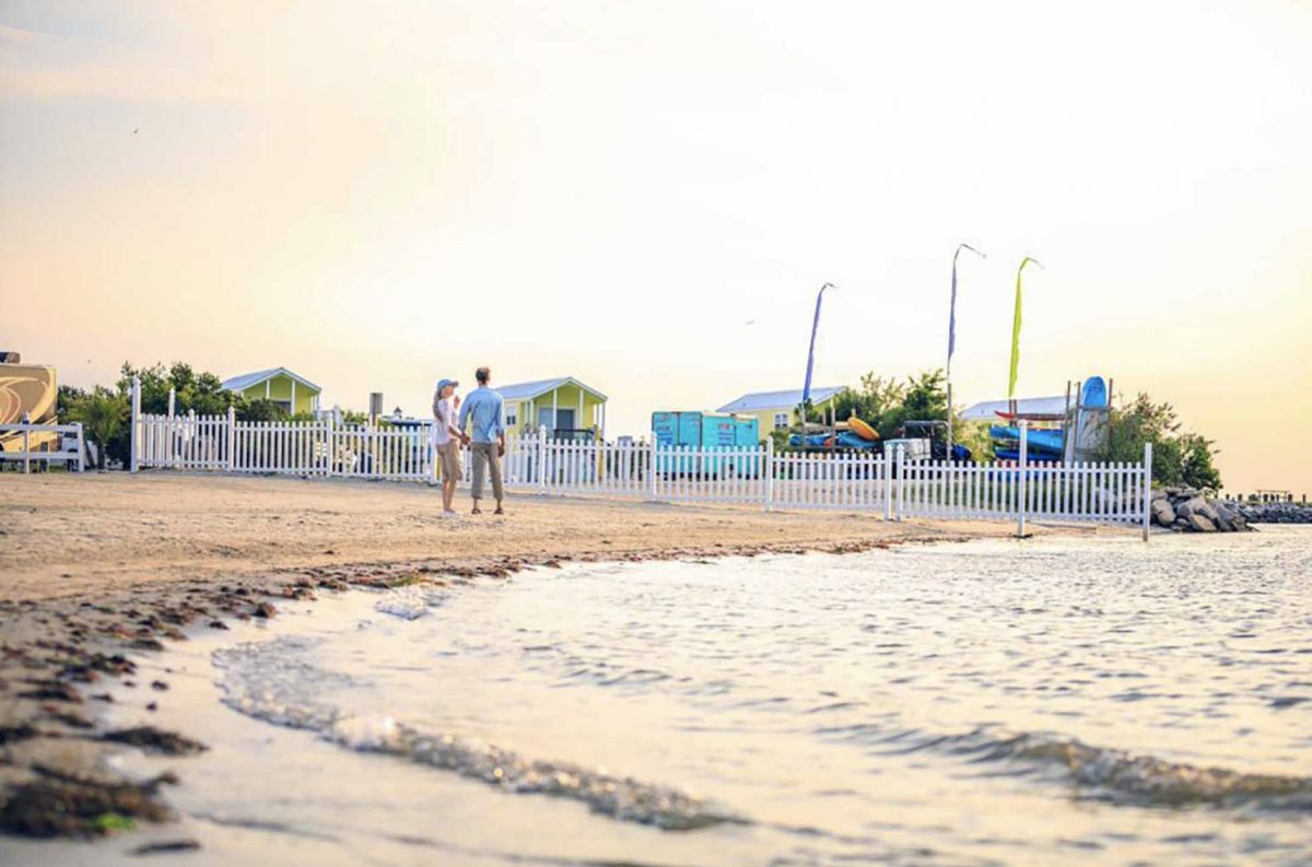 Photo of the ocean shore with a couple holding hands at Castaways RV Resort