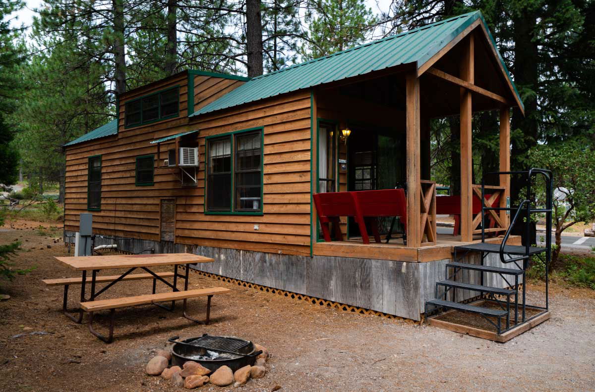 Cabin in the woods with picnic table and fire place at Lake Siskiyou Camp Resort.