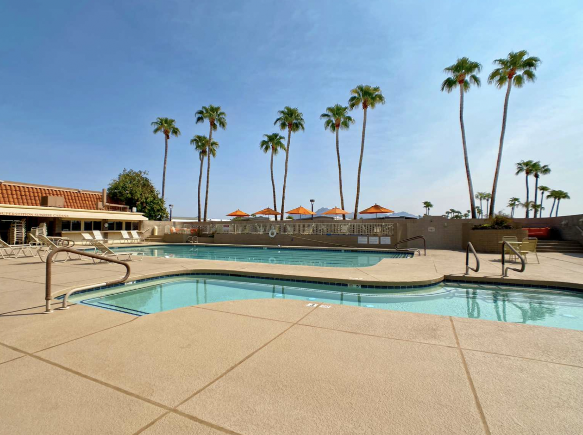 Pool area with palm trees in the background.