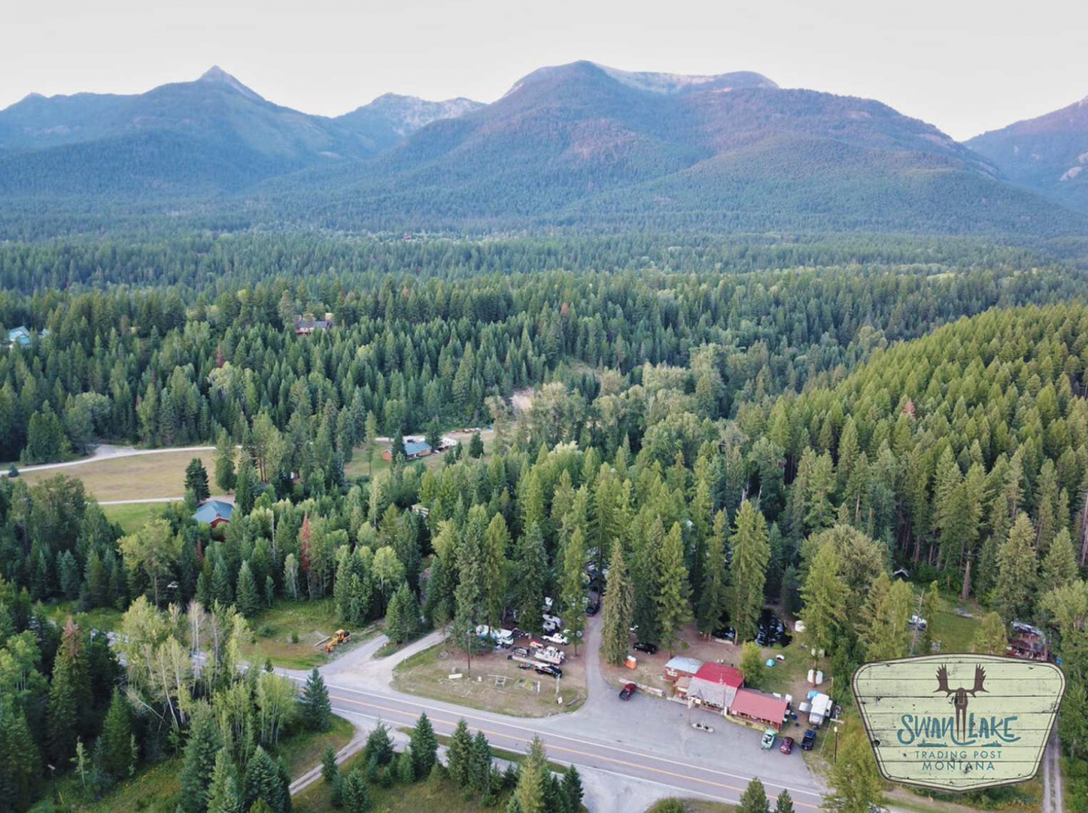 Campground with mountains and pine trees at Swan Lake Trading Post.