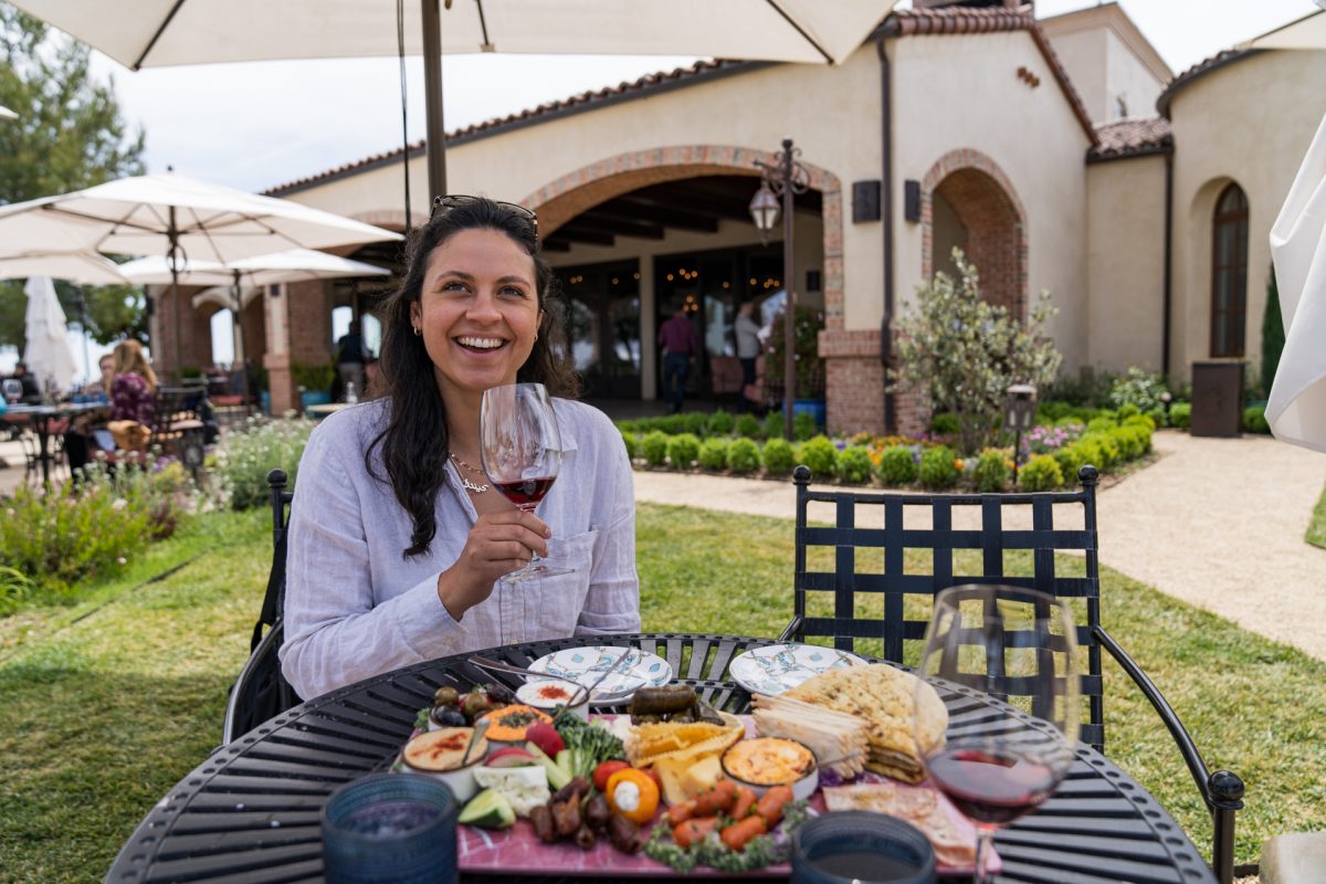 A woman smiles as she drinks red wine at Dauo Vineyards in Paso Robles, California.