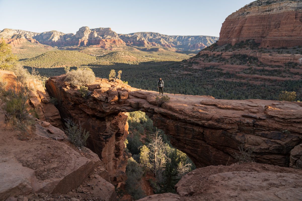 A hiker stands on the Devil's Bridge in Sedona, AZ.