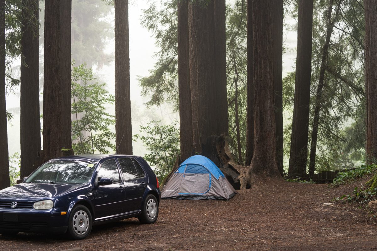 A car and tent sit in the tent area of the Santa Cruz Redwoods RV Resort in Felton, CA.