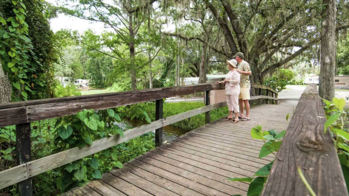 A couple walks on the boardwalk at Mill Creek RV Resort in Kissimmee, Florida