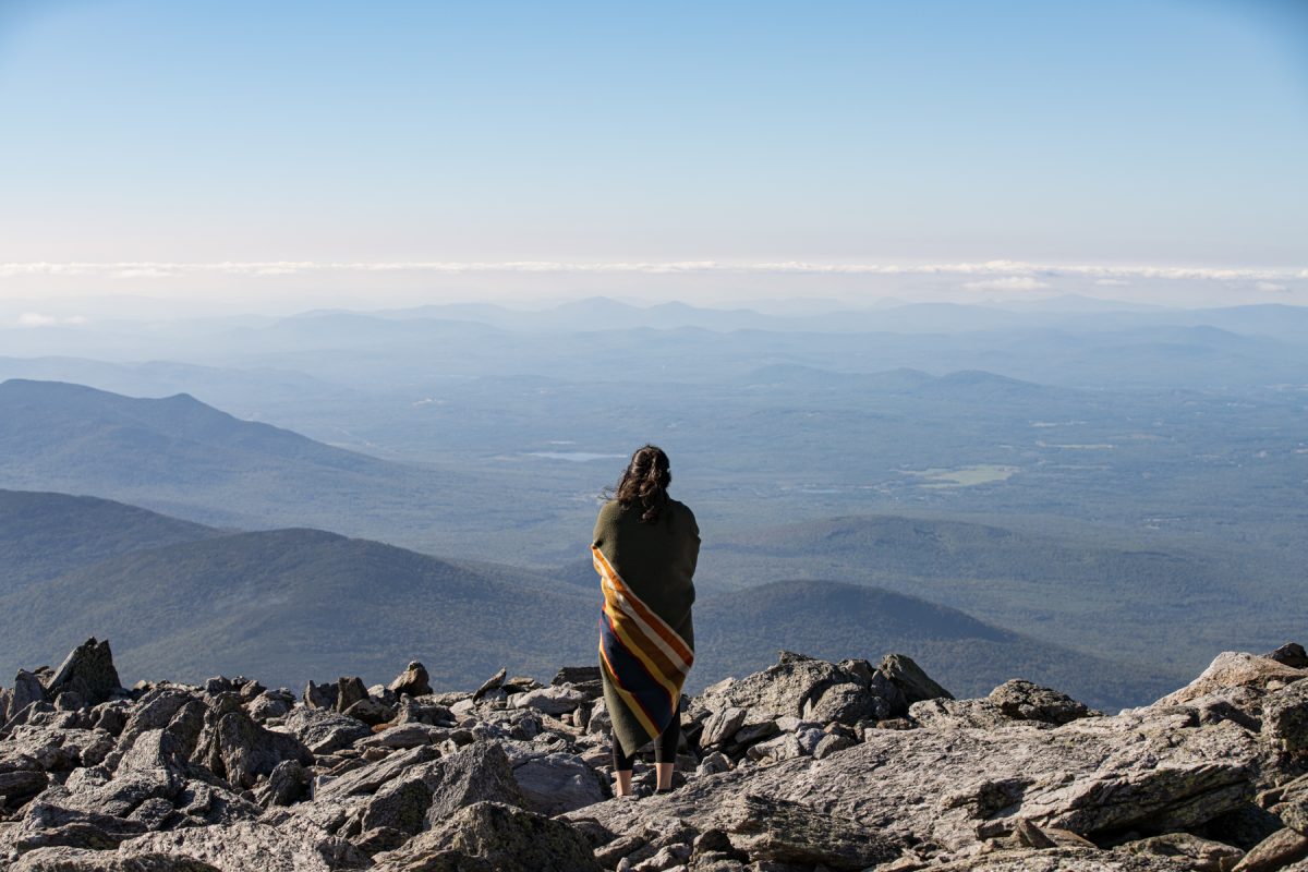 A woman looks out over the White Mountains on Mt. Washington in New Hampshire.