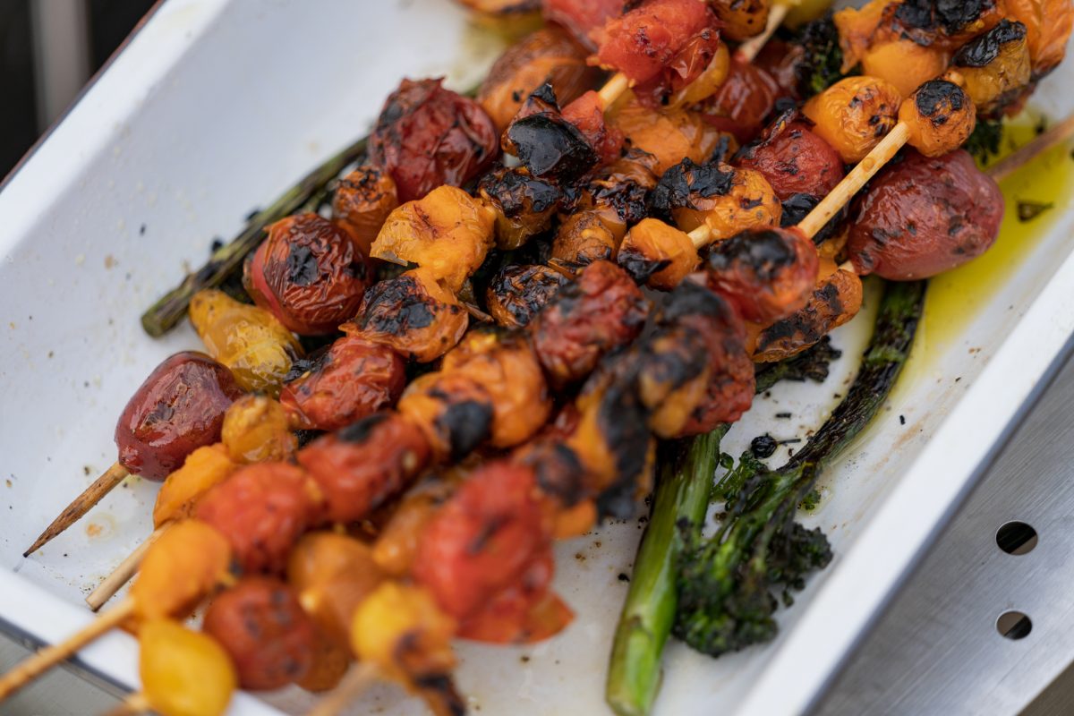 Roasted cherry tomatoes on skewers and roasted broccolini for campfire roasted tomato pasta.