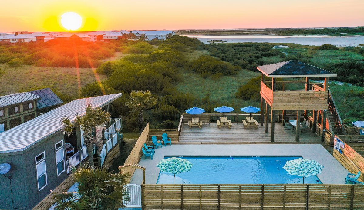 The pool area of the Aloha Beach RV Resort in Port Aransas, Texas, with the sunrise in the distance.