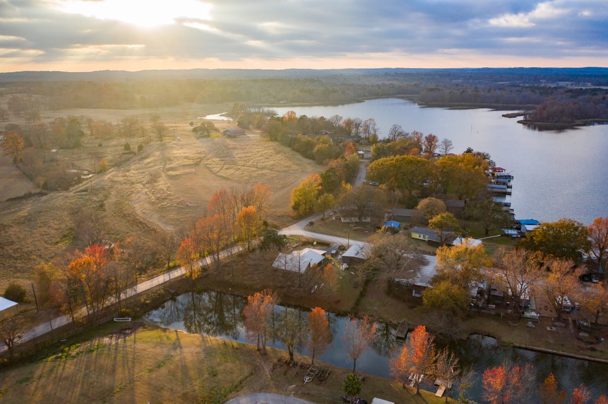 The sunset setting in the backdrop of an aerial view of Lake Palestine Resort in Frankston, Texas.