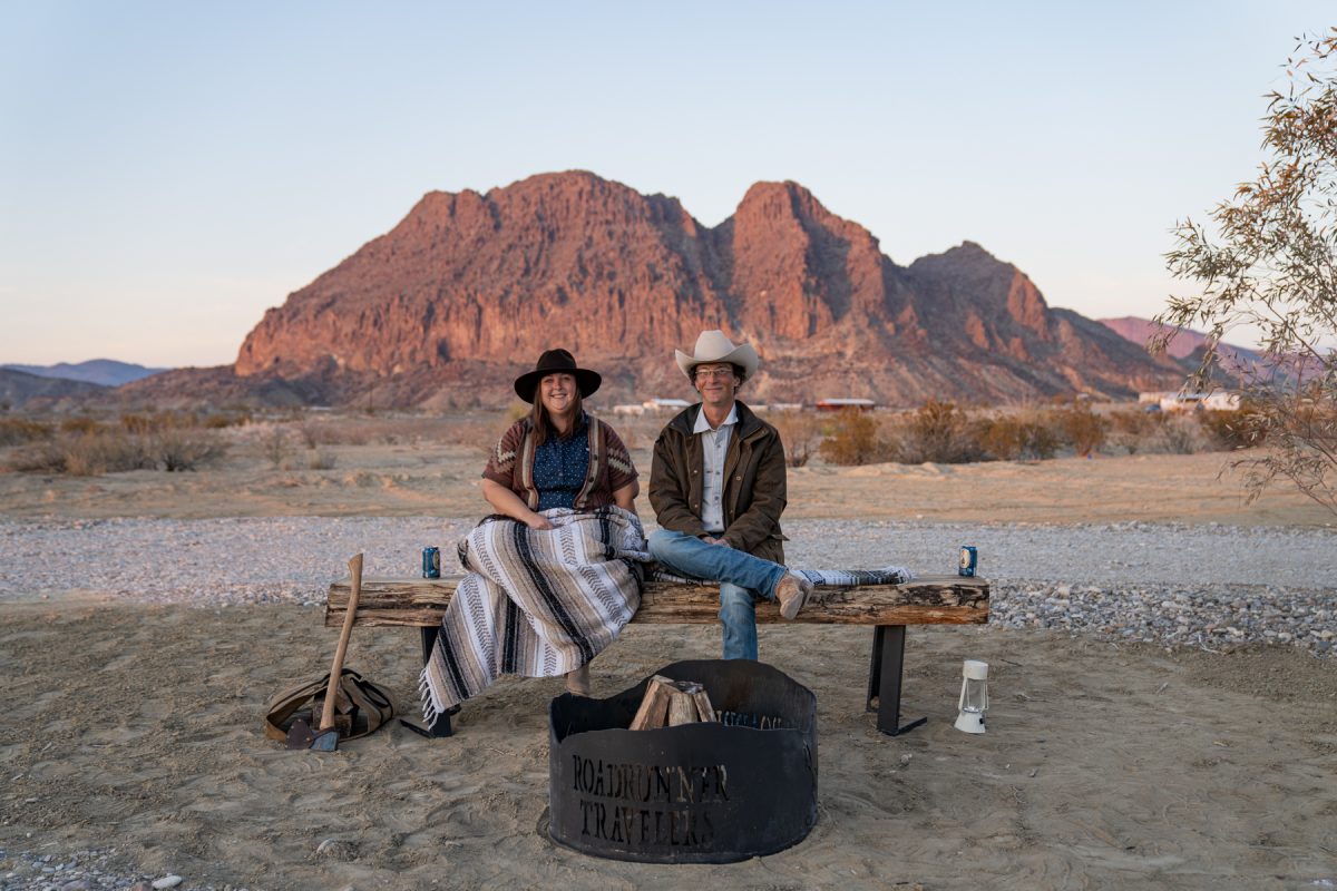 The owners of Roadrunner Travelers Campground in Terlingua, Texas, in front of a campsite and behind Bee Mountain.