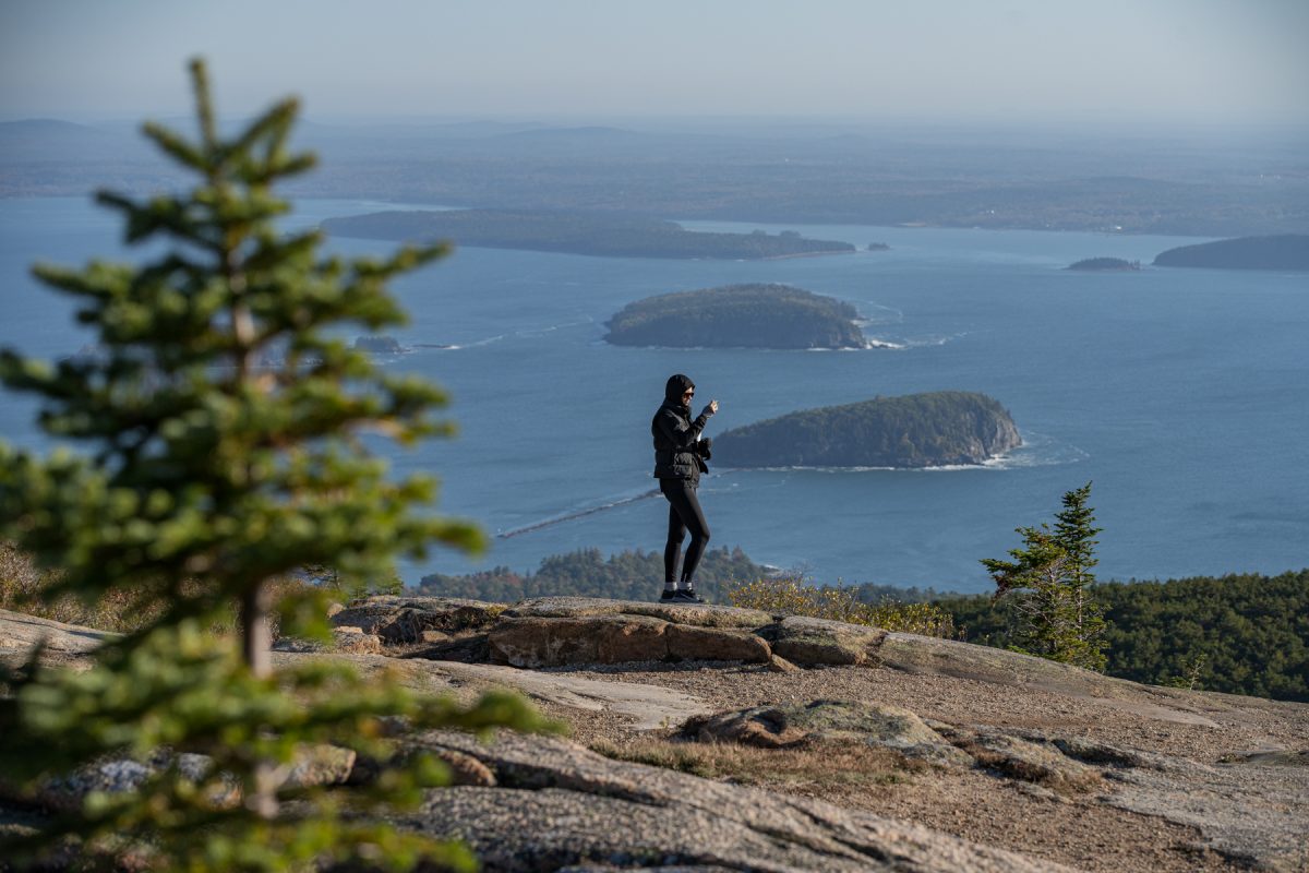 A woman takes a photo from Cadillac Mountain Summit in Acadia National Park in Maine. 