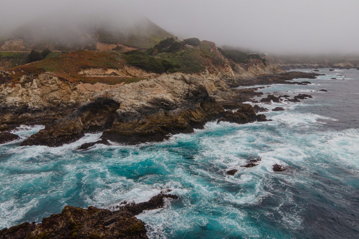 Fog and rugged rocks along Big Sur's Highway 1 in California.