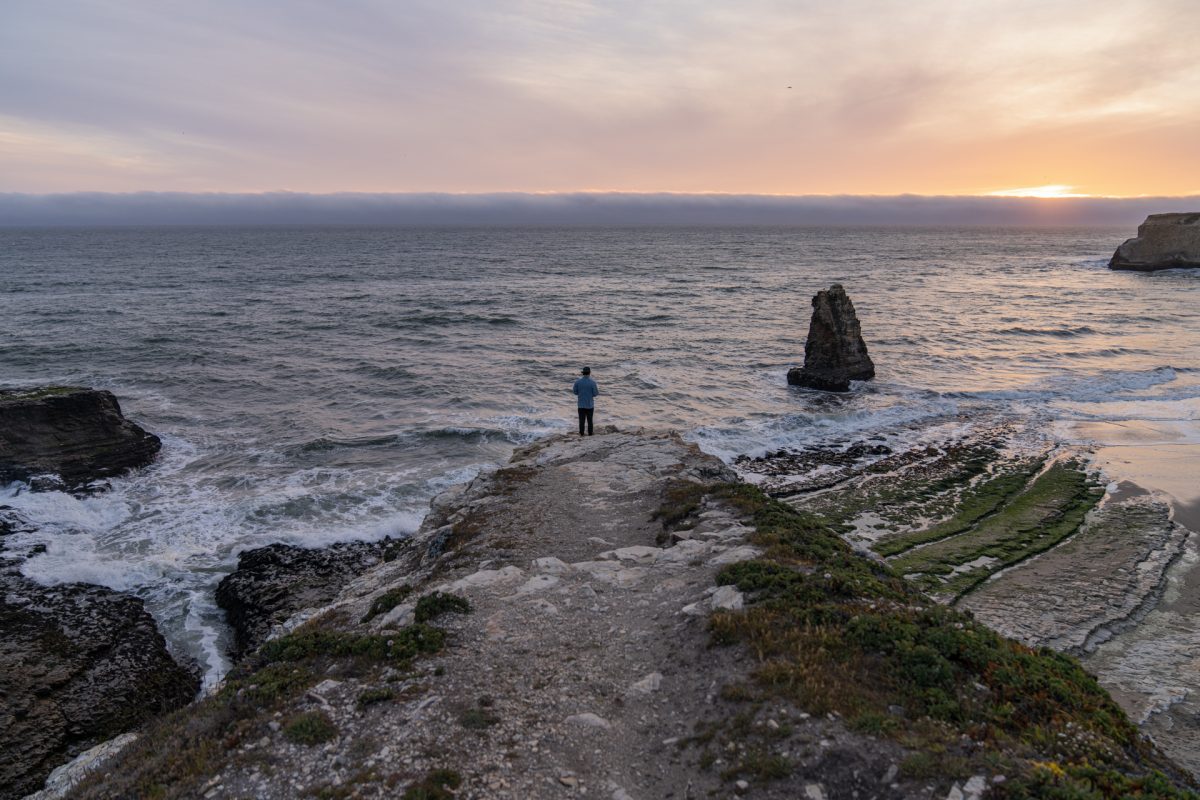 A person looks out over Davenport Cove near Santa Cruz, California.